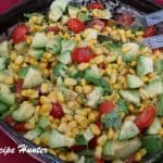 Delicious side dish or afternoon meal of Grilled corn avocado tomato salad with lime