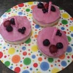 Raw Vegan Raspberry Cheesecake with berries as decoration and a birthday candle