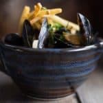 Fresh black mussels in a blue ceramic bowl
