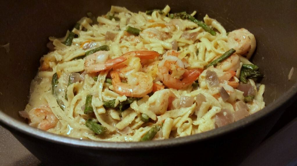 A bowl of Spaetzli with asparagus and shrimp