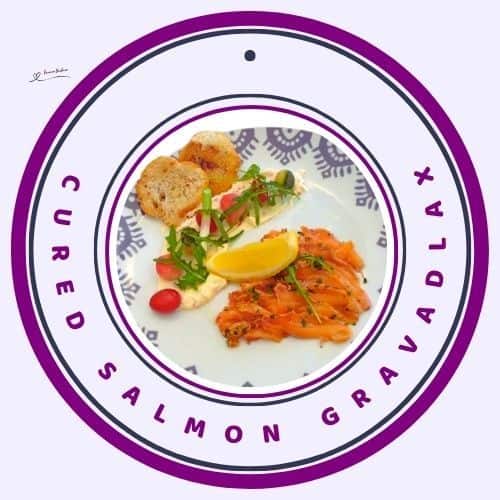 an image of Cured Salmon Gravadlax served with greens, tomato, lemon and croutons