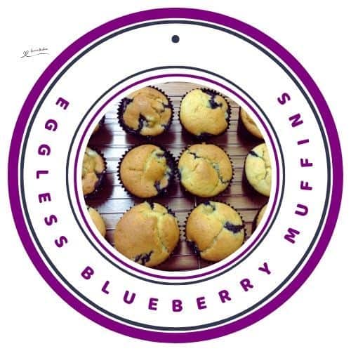 an image of Eggless Blueberry Muffins in paper cupcake holders on wire rack