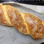 Bread Plait covered with sesame seeds on a baking tray