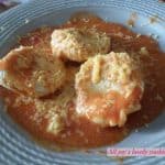 Beef Ravioli in a tomato sauce served in a round blue plate