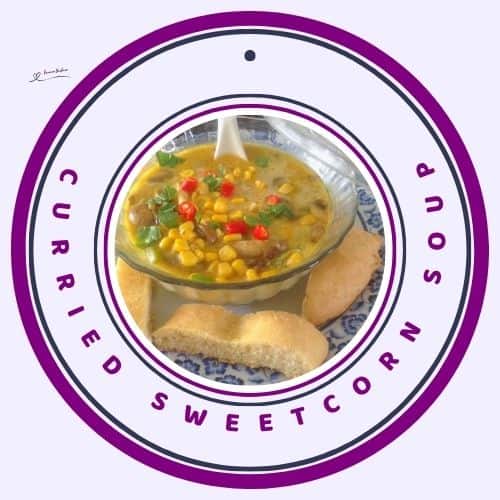 an image of a glass bowl with Curried Sweetcorn Soup and bread on the side