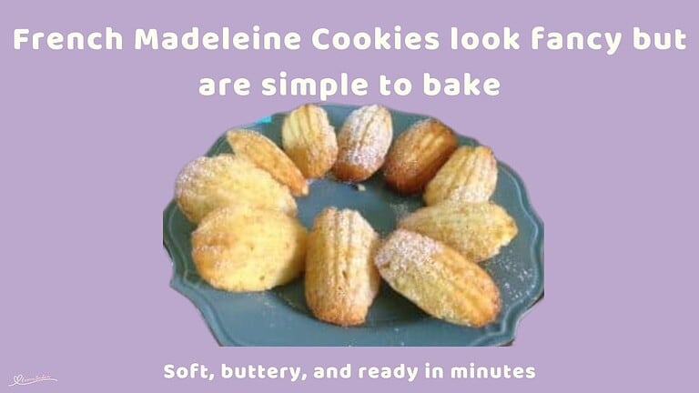 an image of French Madeleine Cookies on a blue serving plate dusted with sugar powder