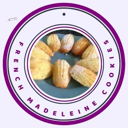 an image of French Madeleine Cookies on a blue serving plate dusted with sugar powder