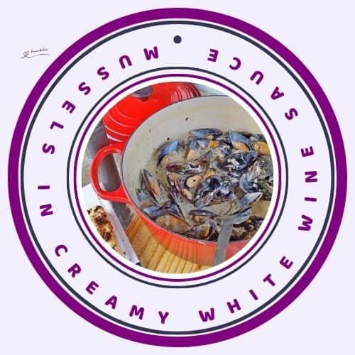 an image of a red cast iron pot with Mussels in Creamy White Wine Sauce