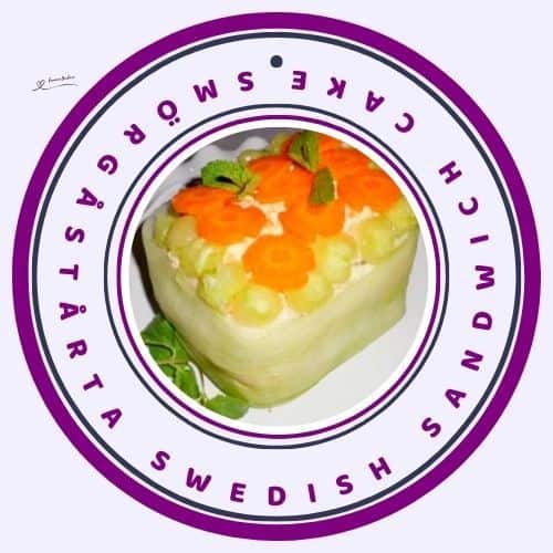 an image of a Smörgåstårta Swedish Sandwich Cake decorated with cucumber ribbons, cucumber balls, and carrot flowers