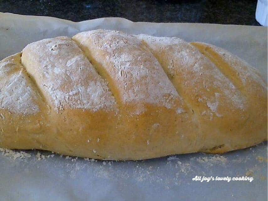 A loaf of bread dusted and topped with flour