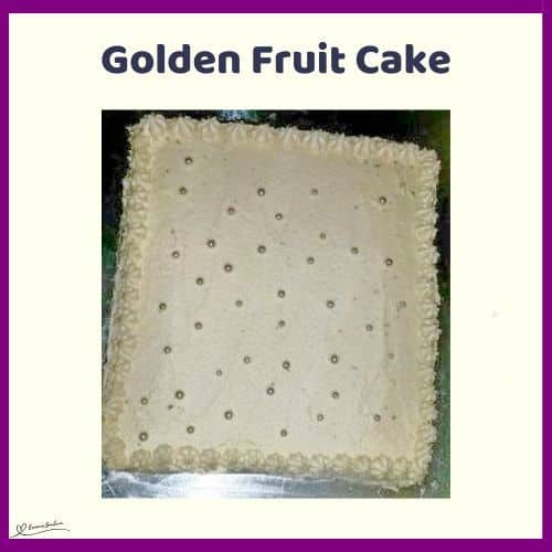 an image of a square Golden Fruit Cake with apricot buttercream icing