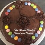 A double layer chocolate cake with smarties and chocolate icing