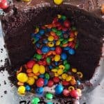 Chocolate Cake cut open and M&M candies flowing out