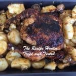 A roasted chicken with baked potatoes