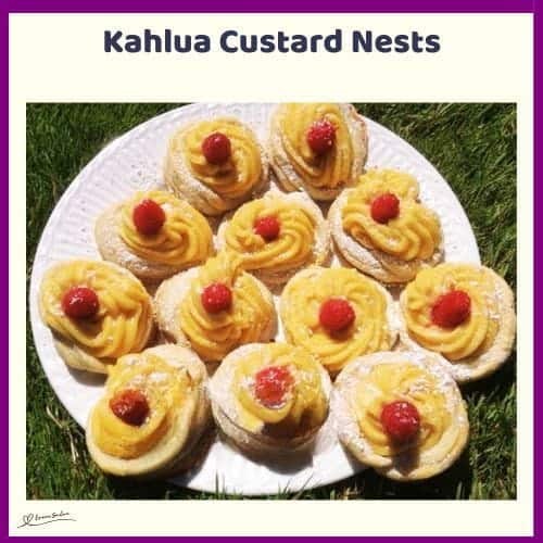 An image of a plate of Kahlua Custard Nests dusted with icing sugar and decorated with fruit