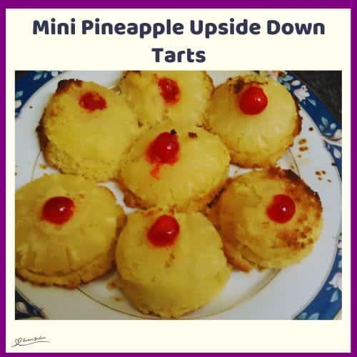 An image of a plate filled with Mini Pineapple Upside Down Tarts and a maraschino cherry in the center