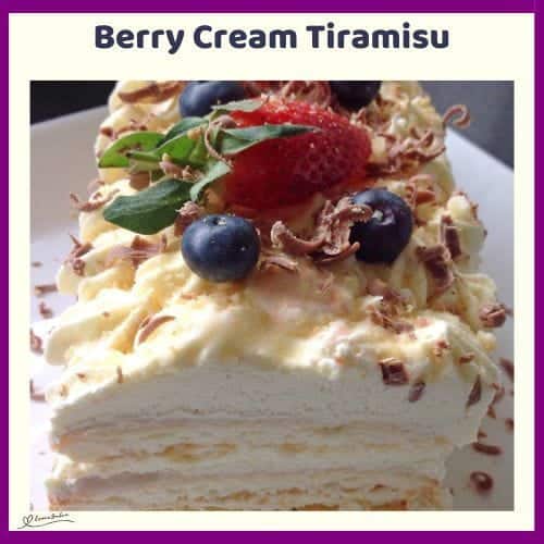 An image of a Berry Cream Tiramisu with boudoir biscuits and topped with blue and strawberries