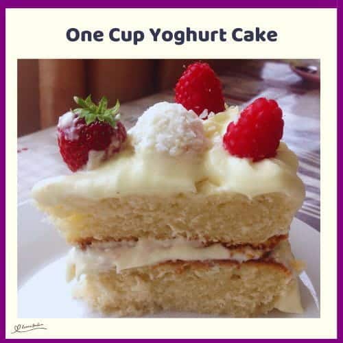 An image of a One Cup Yoghurt Cake covered with whipped cream and decorated with strawberries