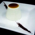 Caramel Panna Cotta with Frangelico Liquor a dessert on a white plate with vanilla pod in the corner