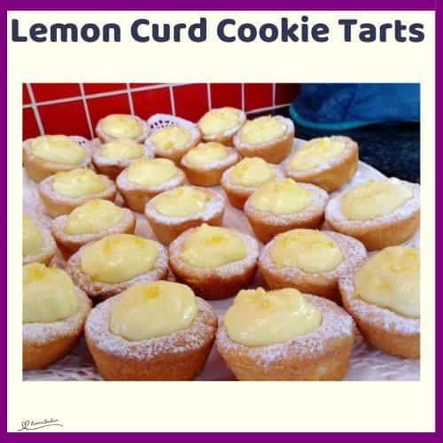 An image of a plate with Lemon Curd Cookie Tarts, dusted with icing sugar