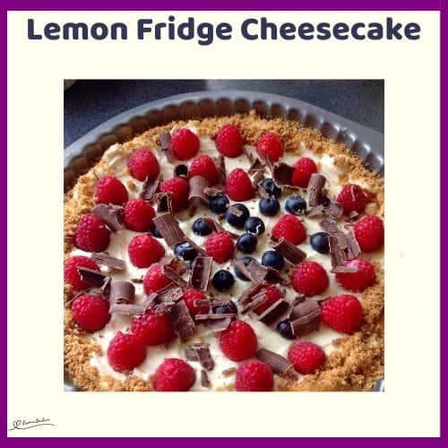 An image of a Lemon Fridge Cheesecake decorated with berries and chocolate shavings