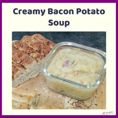 An image of a glass bowl with Creamy Potato Bacon Soup and focaccia on the side