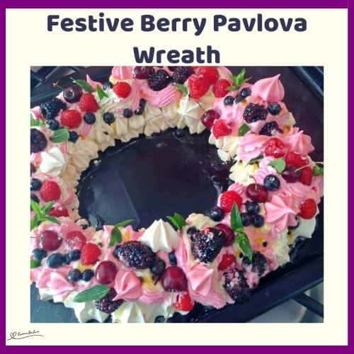 An image of a white and pink Festive Berry Pavlova Wreath with fresh berries and cream