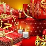 Christmas gifts wrapped with red Christmas wrapping and gold ribbons and white candles