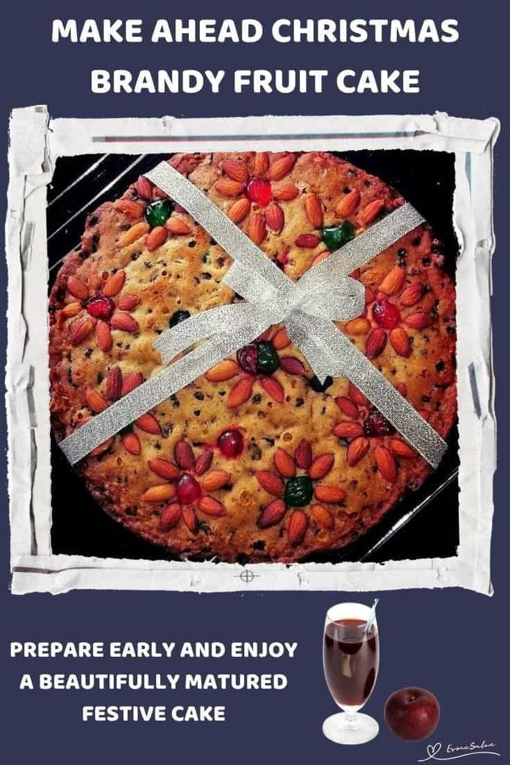 An image of a Christmas Brandy Fruit Cake Decorated with Nuts, Cherries and a Ribbon