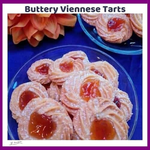 An image of Buttery Viennese Tarts, with jam centers and a dusting of icing sugar