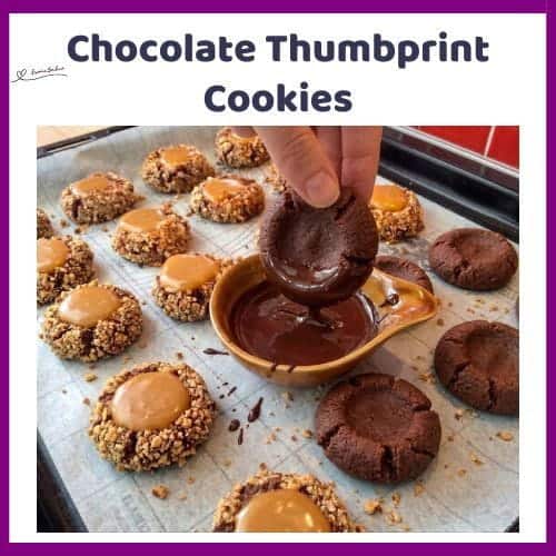 An image of a tray filled with Chocolate Thumbprint Cookies coated with pecan nuts and a caramel centre