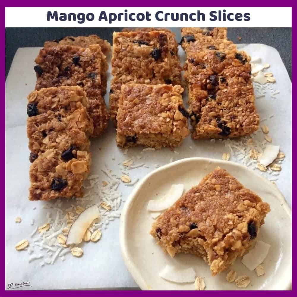An image of a dish of a tray of Mango Apricot Crunch Slices with almonds, coconut, apricots and mango