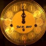 Yellow wall clock with Date Feb 10, 2018 and showing midnight cutoff