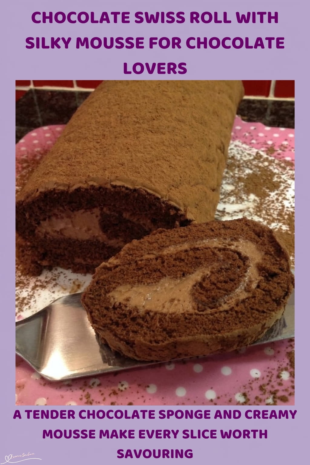 An image of a plate with a Chocolate Swiss Roll, a soft chocolate exterior and a smooth, fluffy Chocolate Mousse filling hidden inside, with a light dusting of cocoa as a finishing touch