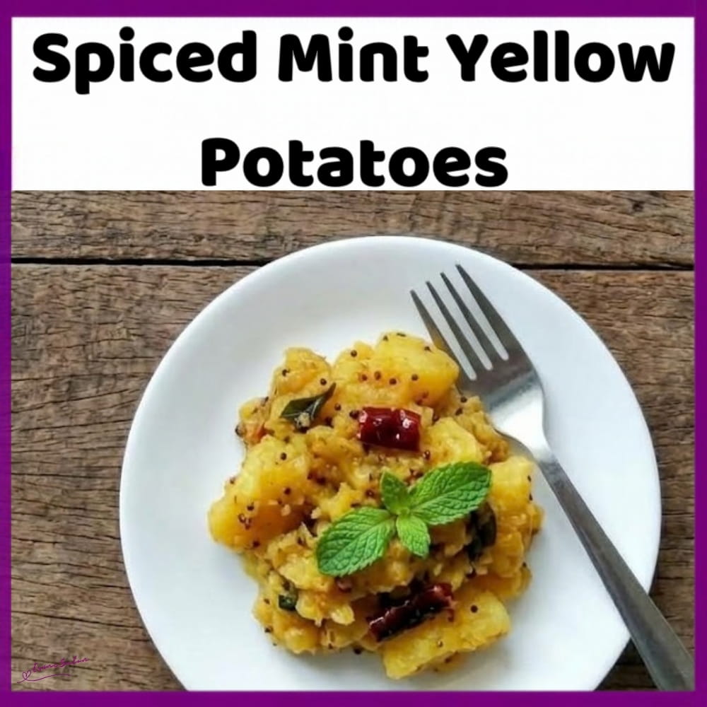 An image of a plate of yellow potatoes with cumin, turmeric and fresh mint