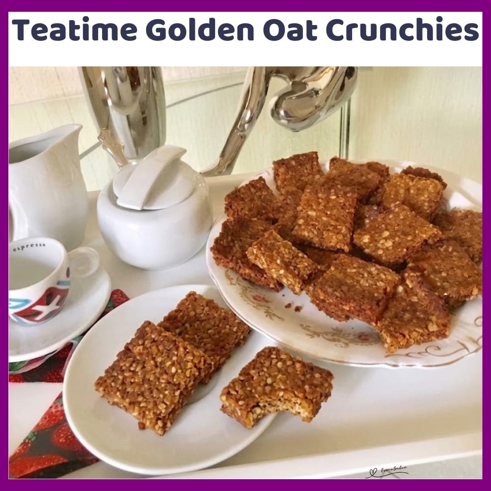 An image of a plate of Teatime Golden Oat Crunchies set out with cups for tea