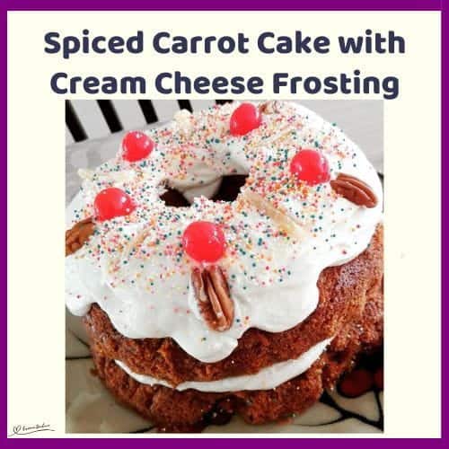 An image of a Bundt Spiced Carrot Cake with Cream Cheese Frosting decorated with nuts and cherries