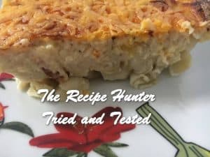 Macaroni And Cheese served on a white plate with a red rose up