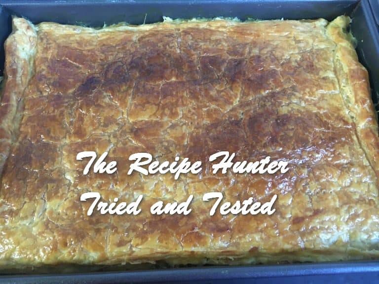 A pyrex dish with Chicken Puff Pastry Pie and nicely browned crust