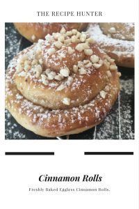 Cinnamon Roll topped with nuts on a cooling wire rack