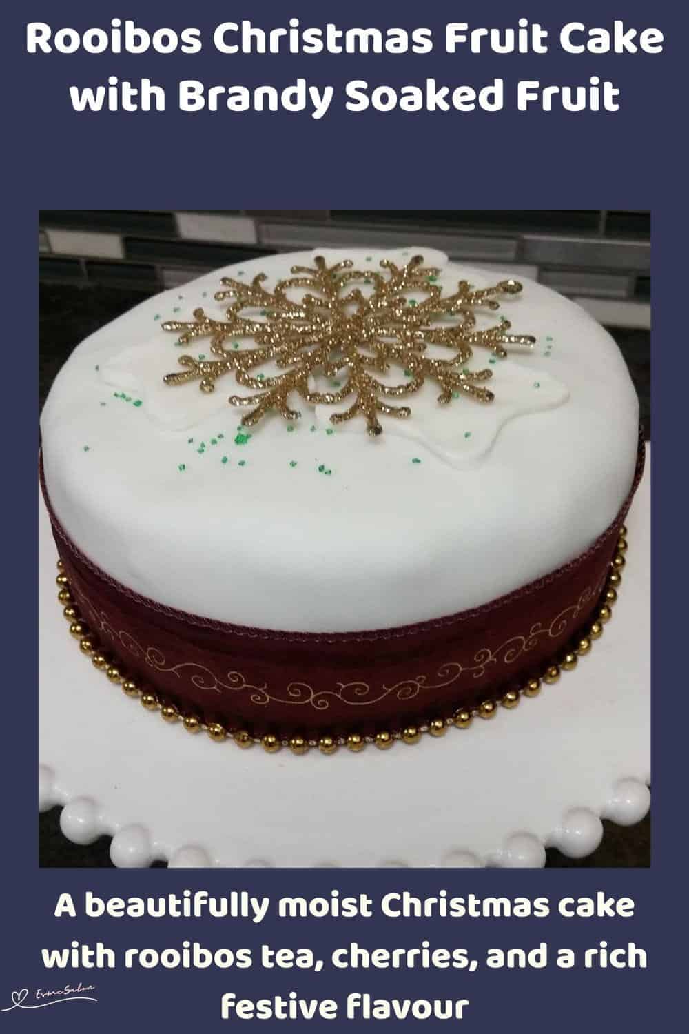 An image of a Rooibos Infused Christmas Fruit Cake covered with white marzipan and decorated with Christmas balls and starts