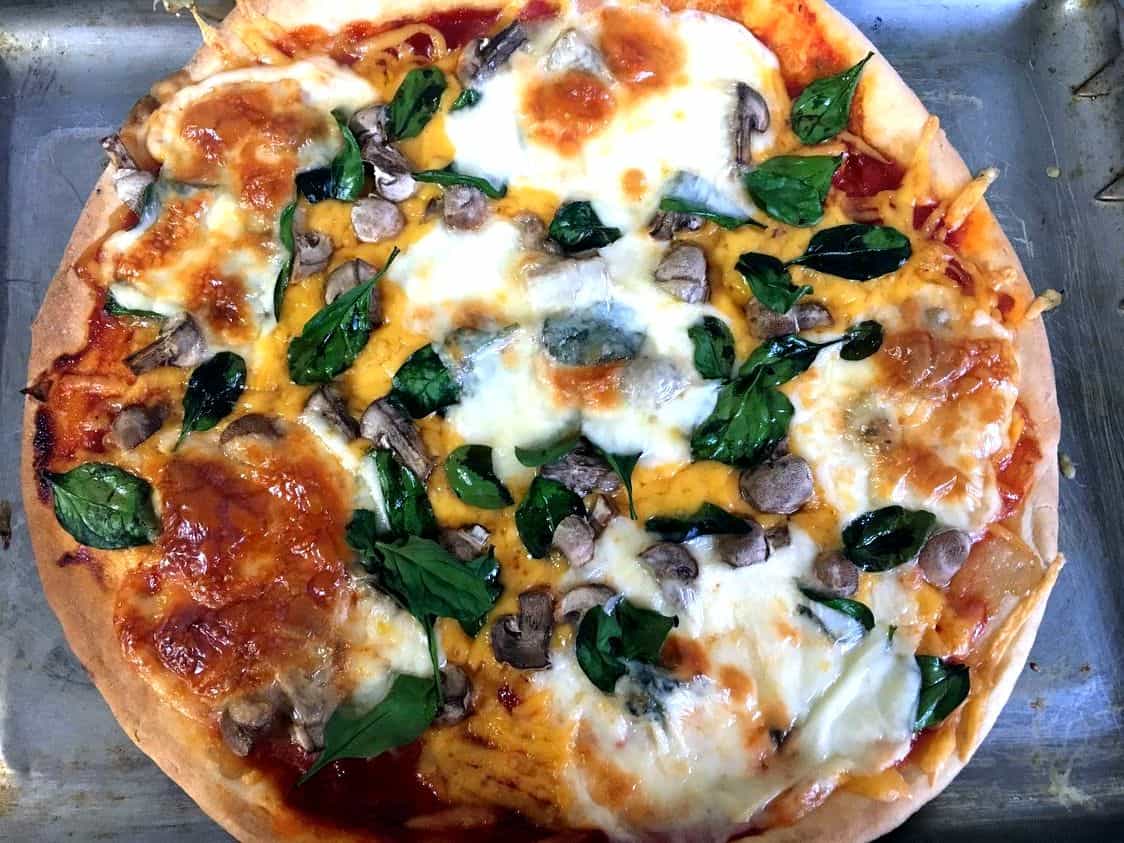 A delicious Cheese Mushroom Basil Pizza with yummy melted cheese