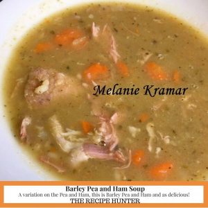 A white bowl filled with Barley Pea and Ham Soup and carrots