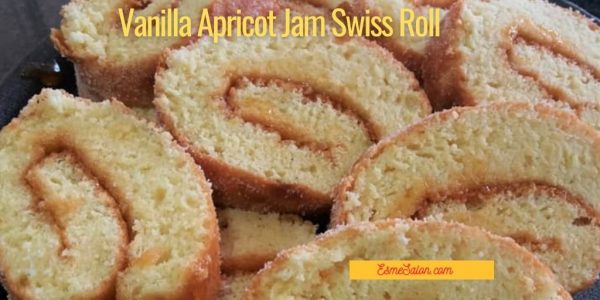 Vanilla Apricot Jam Swiss Roll slices on a glass serving plate