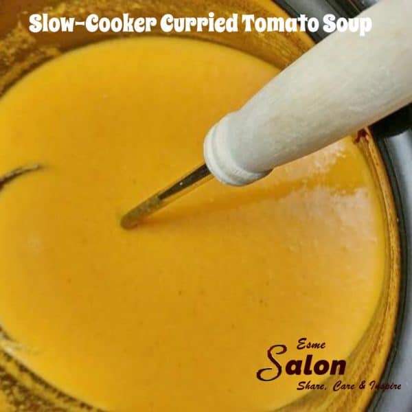 Tomato Soup in slow-cooker and a wooden ladle