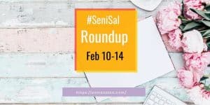 pink flowers next to a white laptop keyboard and white book