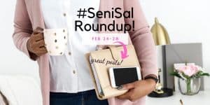 lady with pink jersey and white shirt holding a beige bookbinder with paperwork and iPhone
