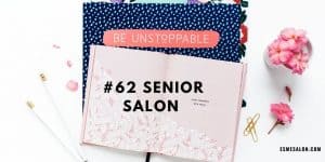 floral pink notepad, with white pencils, golden paperclips and pink flowers on a blue dotted cloth