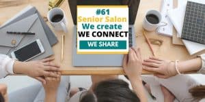 three ladies sitting a desk, with white mugs filled with coffee, open laptop, iPhone and grey paper holder