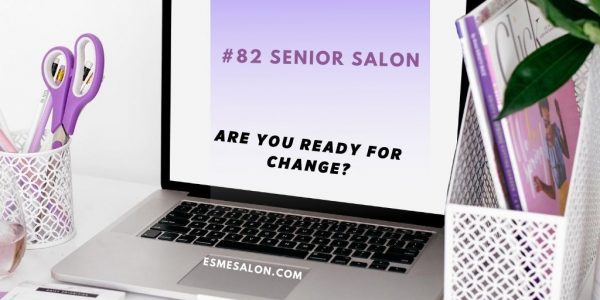 lilac scissors, pen and books next to a silver laptop with black keys and open white screen